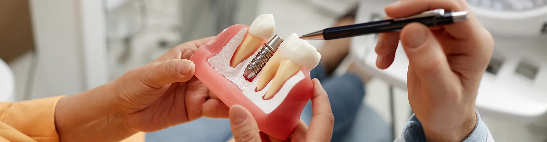 hands holding a large model of an implant