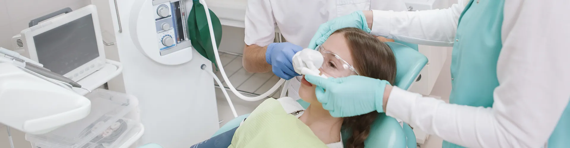 dentists placing breathing mask over patient's nose