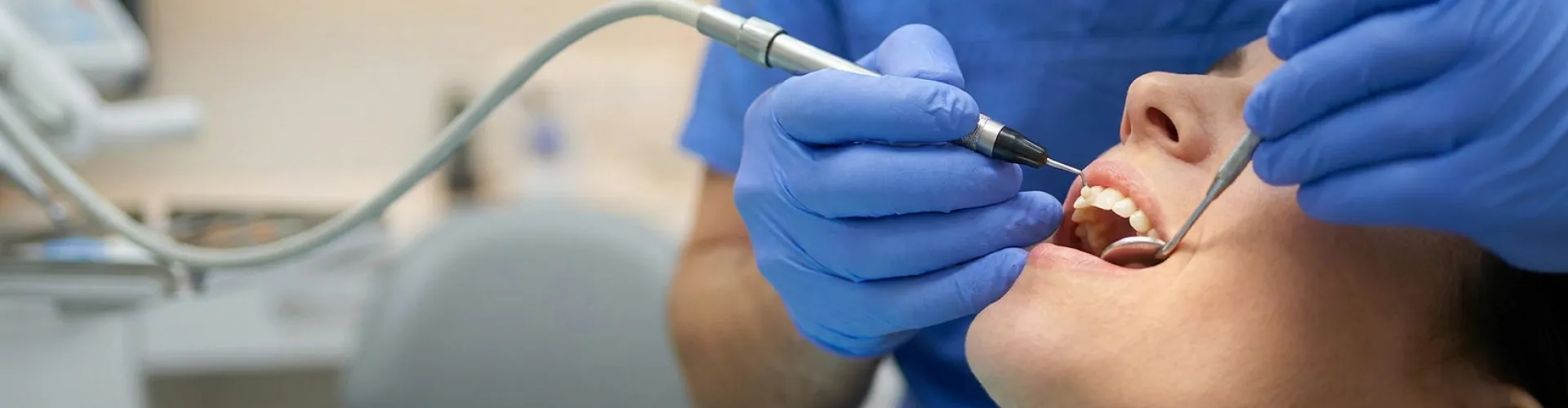 Dentist performing cosmetic dental bonding to close a gap between a patient's front teeth.