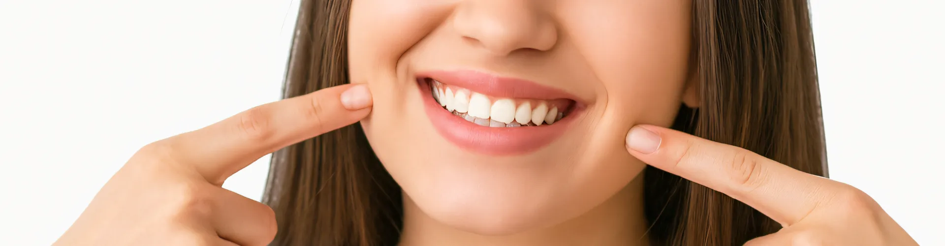Woman pointing at her smile with both hands.