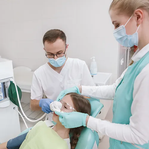dentists placing breathing mask over patient's nose